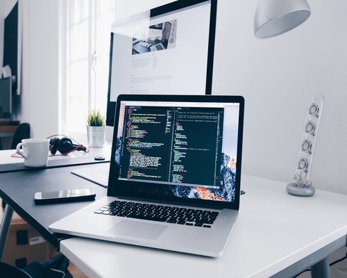 Person adjusting monitor brightness in a home office setup